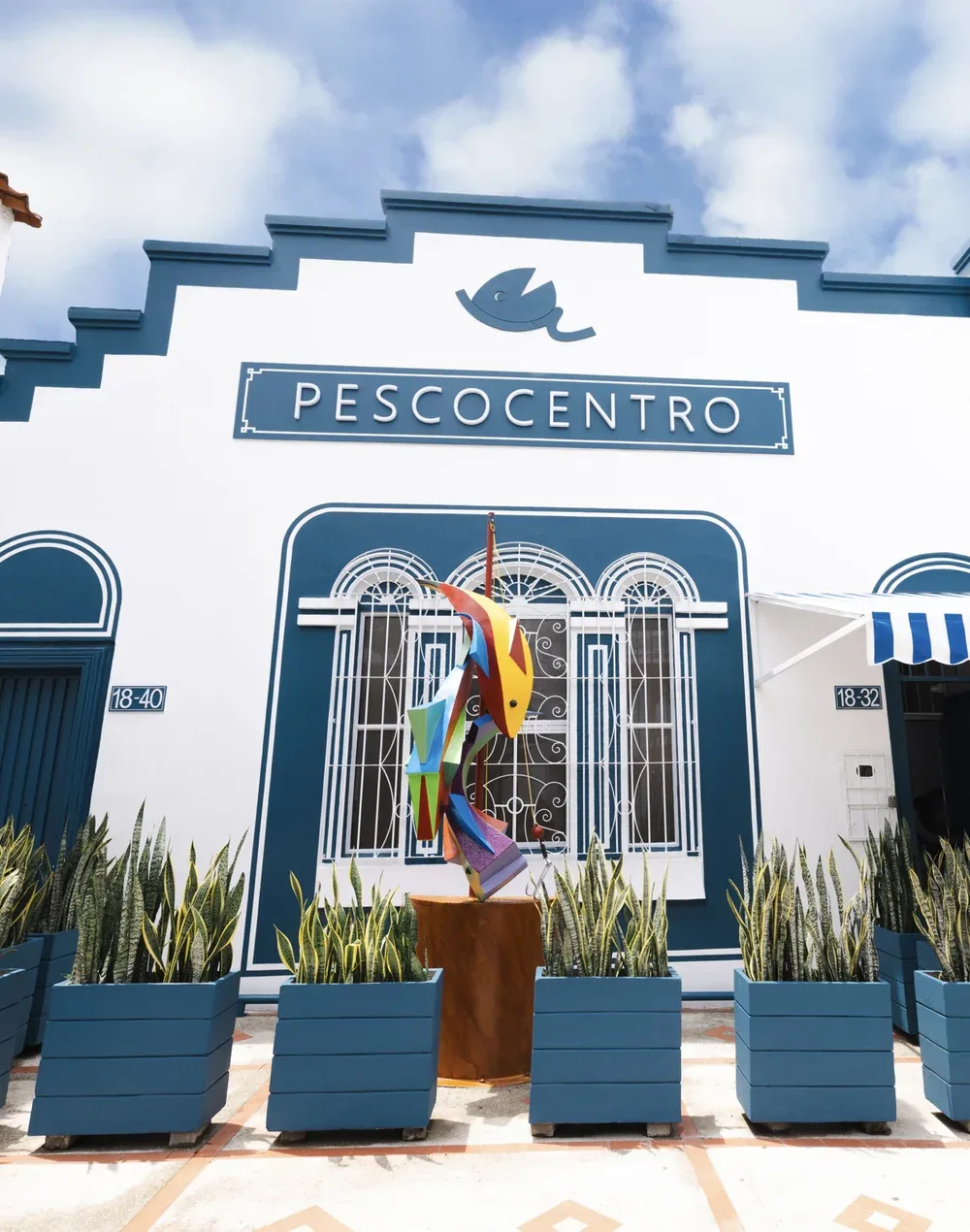 Fachada de Pescocentro Búcaro, Cl. 21 #18-32 Fachada azul y blanca de Pescocentro Búcaro con escultura de pez, Calle 21 en Bucaramanga